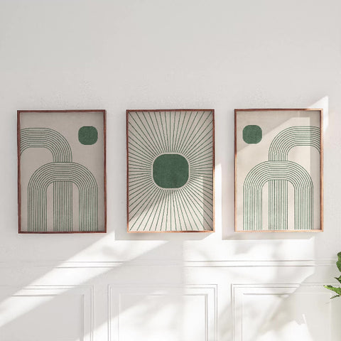 Three abstract art pieces in frames on a white wall